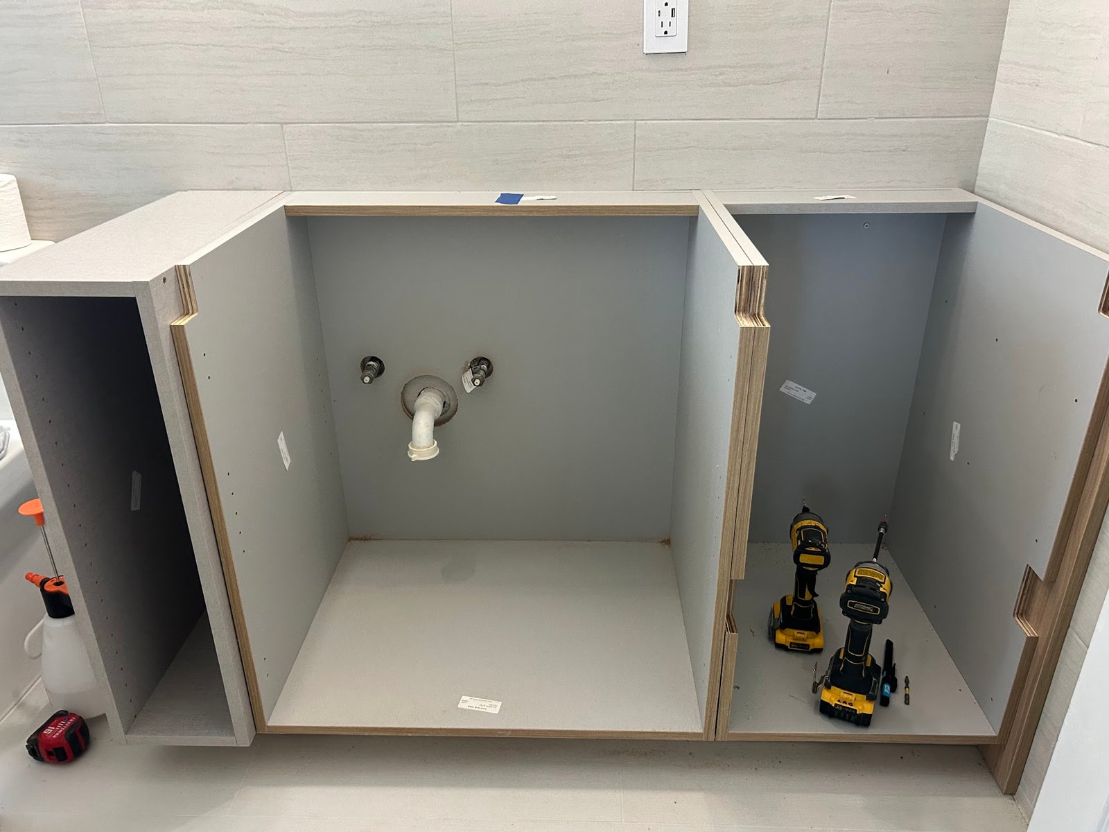 Vanity cabinets aligned to the existing plumbing rough-in during installation by M11 Design Group