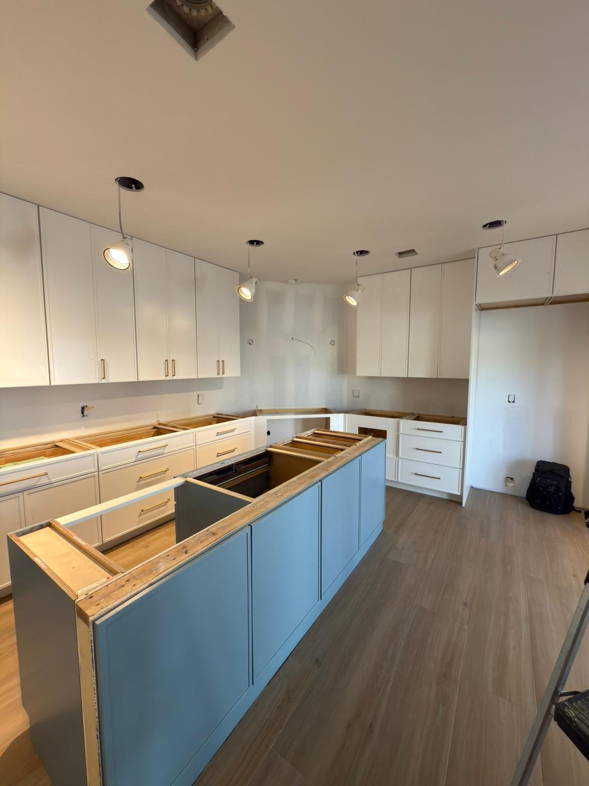 Kitchen island cabinetry being installed on site by the M11 Design Group team