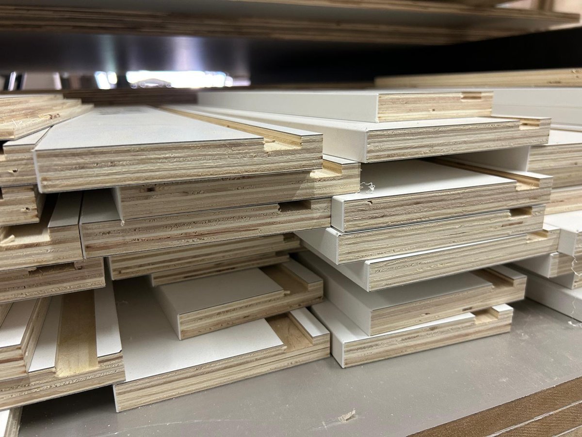 Machined drawer components stacked and ready for assembly in the M11 Design Group shop