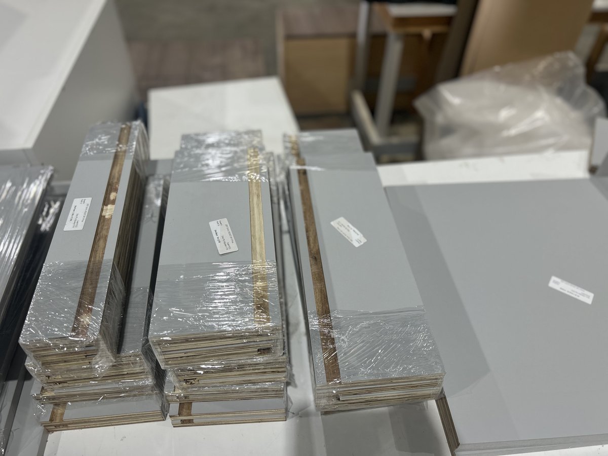 Wrapped and labeled cabinet components received and counted at the M11 Design Group shop