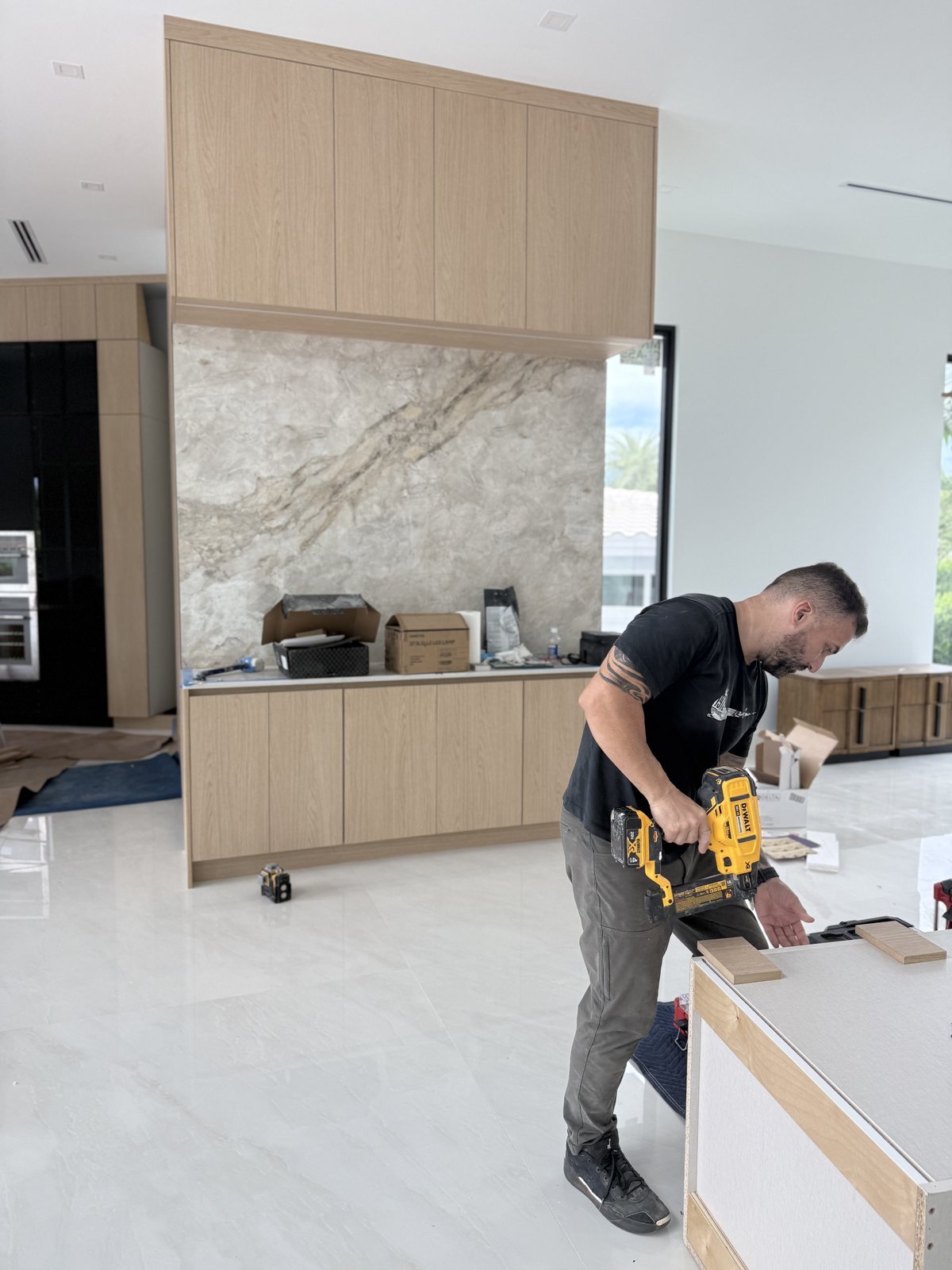 M11 Design Group installer fastening a cabinet box on site in a South Florida home